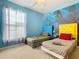 Bedroom with two twin beds, ocean mural, and colorful accents at 8908 Legacy Ct # 201, Kissimmee, FL 34747