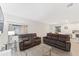 Relaxing living room with two brown reclining sofas and glass coffee table at 11836 Language Way, Orlando, FL 32832