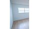 Bright bedroom featuring a large window and updated laminate floors at 100 El Camino Dr # 102, Winter Haven, FL 33884