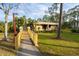 Charming single-story home with a welcoming walkway, manicured lawn and vibrant landscaping at 100 El Camino Dr # 102, Winter Haven, FL 33884