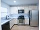 Efficient kitchen featuring stainless steel appliances, light countertops, and updated hardware at 100 El Camino Dr # 102, Winter Haven, FL 33884
