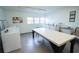 Functional laundry room with multiple washers, a folding table, and a sink at 100 El Camino Dr # 102, Winter Haven, FL 33884