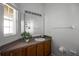 Bright bathroom featuring a vanity with wooden cabinets, a large mirror, and natural light at 1068 Park Ridge Cir, Kissimmee, FL 34746