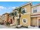 Inviting yellow townhome with palm trees, complemented by white trim and a red tile roof at 1068 Park Ridge Cir, Kissimmee, FL 34746