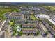 Aerial view of townhouses community, including a pool and surrounding landscape at 1076 Taramundi Dr, Oviedo, FL 32765