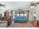 Living room with hardwood floors, blue couch, and view of the pool through sliding doors at 1107 Seafarer Ln, Winter Springs, FL 32708