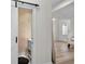 Powder room with barn door and rustic wood paneling at 11401 Camden Park Dr, Windermere, FL 34786