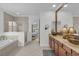 Primary bathroom featuring double sinks, a soaking tub, and a glass-enclosed shower at 11413 Camden Park Dr, Windermere, FL 34786