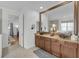 Primary bathroom featuring double sinks with granite counters, and a large framed mirror at 11413 Camden Park Dr, Windermere, FL 34786