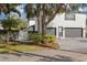 Exterior view of home showcasing a two-car garage and lush landscaping at 11413 Camden Park Dr, Windermere, FL 34786