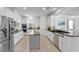 Modern kitchen with stainless steel appliances, white cabinetry, granite countertops, and tile flooring with center island at 11413 Camden Park Dr, Windermere, FL 34786