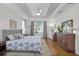 Inviting bedroom featuring tray ceilings, hardwood floors, and large windows creating a light filled space at 11413 Camden Park Dr, Windermere, FL 34786