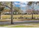 Scenic view of a peaceful pond reflecting houses and trees, with a bench nearby at 11413 Camden Park Dr, Windermere, FL 34786
