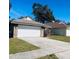 Brick home with a two-car garage and neatly kept lawn at 1216 Windward Dr, Apopka, FL 32703