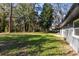 Backyard featuring a large grassy area and mature trees, adjacent to a house with gray siding at 1312 Surf Ave, Apopka, FL 32703