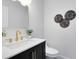 Bathroom vanity with black cabinets, brushed gold faucet, and round metal wall decorations at 1312 Surf Ave, Apopka, FL 32703