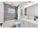 Bathroom featuring marble wall tile, gold fixtures, and a shower and tub combination at 1312 Surf Ave, Apopka, FL 32703