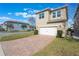 Tan two-story house with white garage door and paver driveway at 14694 Seton Creek Blvd, Winter Garden, FL 34787