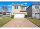 Tan two-story house with white garage doors and paver driveway at 14694 Seton Creek Blvd, Winter Garden, FL 34787