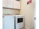 Bright laundry room with washer and dryer and overhead cabinets at 14694 Seton Creek Blvd, Winter Garden, FL 34787