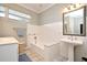 Bathroom with pedestal sink, bathtub, and tiled walls at 1821 Stanley St, Longwood, FL 32750