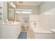 Bathroom with vintage fixtures, white tile, and a window for natural light at 1821 Stanley St, Longwood, FL 32750