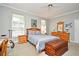 The bedroom has comfortable blue bedding, wood furniture, and bright natural light from the windows at 1821 Stanley St, Longwood, FL 32750
