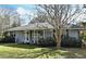 Ranch style home with grey siding, white trim, and rocking chairs on the porch at 1821 Stanley St, Longwood, FL 32750