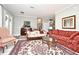 Cozy living room featuring floral sofas, an ornate rug, and ample natural light from a nearby window at 1821 Stanley St, Longwood, FL 32750