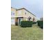 Side view of tan townhome with lush green landscaping at 1976 Estancia Cir # 1976, Kissimmee, FL 34741