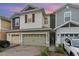 Two-story townhome with a light green garage door and landscaped front yard at 2583 Sedge Grass Way, Orlando, FL 32824