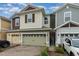 Two-story townhome with a light green garage door and landscaped front yard at 2583 Sedge Grass Way, Orlando, FL 32824