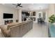 Open floor plan with a gray couch, kitchen island, and dining area at 2583 Sedge Grass Way, Orlando, FL 32824