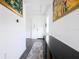 View of entryway with grey wood-look tile floors, a black console table and artwork at 2709 Greenlands St, St Cloud, FL 34772