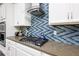 Gas cooktop and modern blue chevron backsplash in kitchen at 2709 Greenlands St, St Cloud, FL 34772