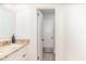 Bright bathroom featuring a granite countertop, white cabinetry, and an doorway leading to an adjacent room at 2825 Greenfield Ave, Orlando, FL 32808