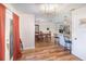 Open dining area with dark wood floors, chandelier, and a view into the kitchen area at 2825 Greenfield Ave, Orlando, FL 32808