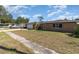 Street view of the house with a well maintained lawn, landscaping, and a two car garage at 2825 Greenfield Ave, Orlando, FL 32808