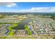 An aerial view of a lakeside community featuring colorful homes, lush green spaces, and roadways at 3020 Latitude Ln, Kissimmee, FL 34747