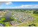 Aerial view of a colorful neighborhood with vibrant houses, a lake, and surrounding greenery at 3020 Latitude Ln, Kissimmee, FL 34747