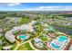 High aerial view of resort, pools, and hotel surrounded by lake, colorful townhomes, and shopping center at 3020 Latitude Ln, Kissimmee, FL 34747