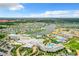 Wide aerial shot of community featuring colorful homes, central lake, resort pools, and hotel at 3020 Latitude Ln, Kissimmee, FL 34747