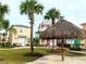 The community has a tiki hut, beachy landscaping, and is surrounded by colorful beach homes, creating a tranquil setting at 3020 Latitude Ln, Kissimmee, FL 34747