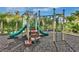 Community playground with green slides, climbing bars, and a secure rubber mulch surface at 3020 Latitude Ln, Kissimmee, FL 34747