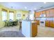 Bright kitchen with center island, white appliances, and adjacent dining area with green chairs at 3442 Starbird Dr, Ocoee, FL 34761