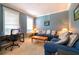 Inviting living room with a comfortable blue sofa and a dedicated workspace at 3442 Starbird Dr, Ocoee, FL 34761