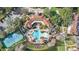 Aerial view of a community clubhouse with a pool, tennis courts, and lush landscaping at 417 Pavia Loop, Lake Mary, FL 32746