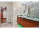 Bathroom featuring double sinks with green marble countertop, vanity and walk-in closet at 417 Pavia Loop, Lake Mary, FL 32746