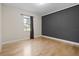 Bright bedroom with hardwood floors, neutral walls, a gray accent wall, and a large window at 417 Pavia Loop, Lake Mary, FL 32746