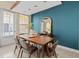 Inviting dining room featuring a wooden table, modern chairs, and stylish decor against a blue accent wall at 417 Pavia Loop, Lake Mary, FL 32746